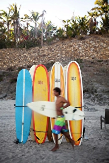 Blurry Prints: A surfer runs to the waves next to a stack of boards at Los Cerritos near Pescadero