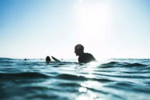 Contrast Prints: surfer waiting for wave, sitting on board, blue