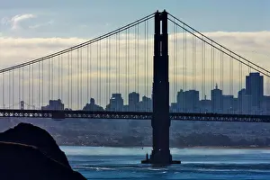 Suspension Bridge Prints: Suspension bridge across the bay with city skyline in the background
