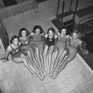 Black Andwhite Prints: Swimmers in the 1940s. A group of young female swimmers are sitting together beside the pool