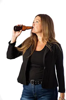 Alter Prints: Taking a sip of beer Isolated portrait of a forty year old woman in a sport coat taking a sip from a brown beer bottle