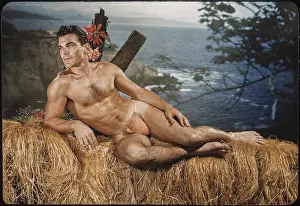 Bodybuilder Prints: Tanned Nude Bodybuilder Relaxes on Ocean View Balcony c.1951