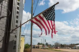 Us Flag Prints: Tattered American flag flying on a building on Main Street