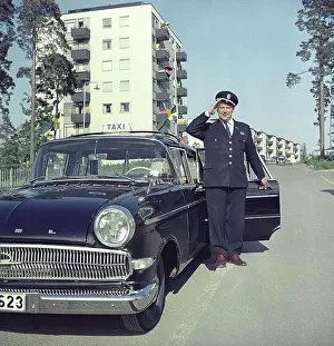 1960s Prints: Taxi driver in the 1960s. A taxi driver at his car