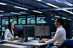 System Prints: Team of technicians in data center checking equipment performance on computer after upgrading infrastructure