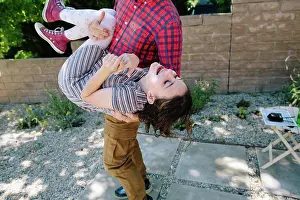 Stripes Prints: Teen Girl Laughs As Her Father Holds Her And Dips Her