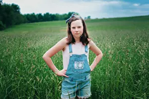 Overalls Prints: Teen Girl in Overall Shorts Standing in Grassy Field in the Midwest