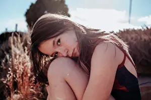 People In Nature Prints: Teen girl in a swimsuit sitting outside on a sunny day
