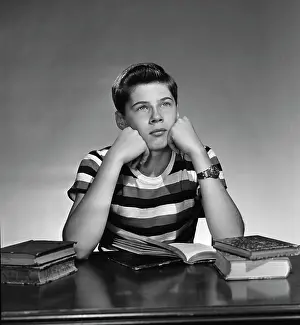 Dreaming Prints: teenage boy sitting wit books open and looking away