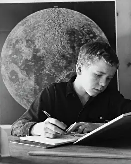 Planet Prints: Teenage boy writing in a spiral notebook