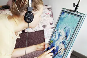 Daughter Prints: A teenage girl collects a diamond mosaic on an easel