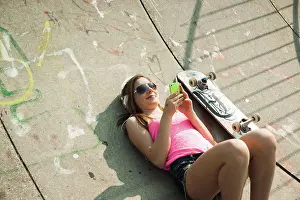Skateboard Prints: Teenage Girl Listening to MP3 Player in Skatepark