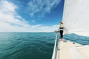 Life Jacket Prints: Teenage girl on front of sailboat with blue sky