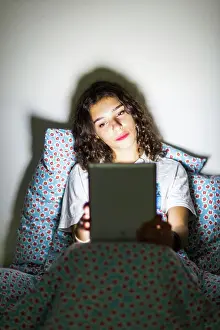 Wifi Prints: Teenage girl using a digital tablet at night