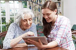 Tablet Computer Prints: Teenage Granddaughter Showing Grandmother How To Use Digital Tablet