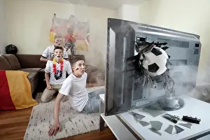 Groups Of People Prints: Teenage soccer fans in living room with ball demolishing TV