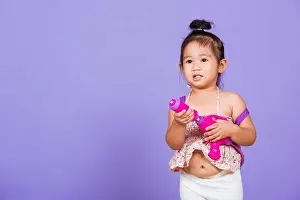 Fight Prints: Thai child funny hold toy water pistol and smile