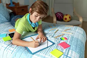 Thoughtful Prints: Thoughtful schoolboy in casual wear and wireless headphones enjoying music
