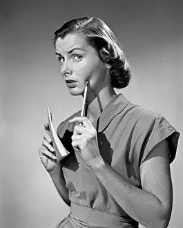Contemplating Prints: Thoughtful young woman holding pen and notepad