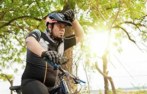 Cycling Prints: Tired cyclist while riding the bike on a road
