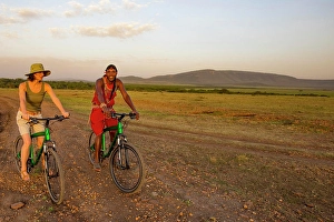 Biking Prints: Tourist with guide on mountain bike safari in the Maasai Mara National Reserve
