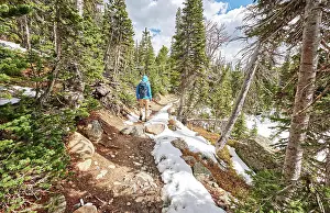 Hike Prints: Tourist mit Rucksack beim Wandern auf verschneitem Weg Tourist with backpack hiking on snowy trail in Rocky Mountain