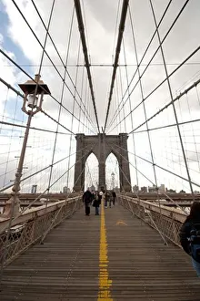 Architectural Prints: Tourists and commuters walk along the pedestrian deck of the Brooklyn Bridge