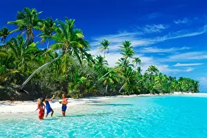 Locations Prints: Tourists drinking from coconuts off One Foot Island in Aitutaki lagoon in Cook Islands