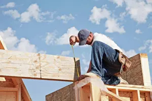 Measuring Prints: tradesman working on framing for new home construction, st. albert alberta canada
