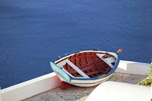 Greece Prints: A traditional old fishing boat perched on a rooftop above the sea in Oia
