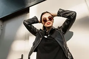 Schatten Prints: Trendy junge schöne Frau Modell in der Mode schwarze Kleidung mit Leder stilvolle Jacke mit Vintage Runde Sonnenbrille