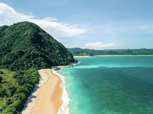 Refreshing Prints: Tropical beach with turquoise waters and lush green hills under a clear blue sky