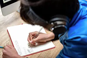 Notebook Prints: UK, Boy in headphones writing in notebook