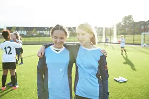 Multiracial Group Prints: UK, Portrait of female soccer team members embracing in field