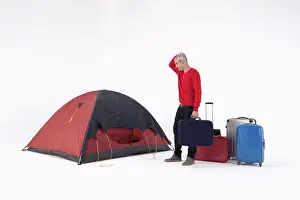 Sweater Prints: An unhappy man with loads of luggage looking at a tent with uncertainty