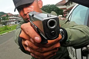 Uniform Prints: Uniformed police officer aiming a pistol at a tactical