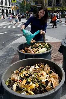 Vegetables Prints: Union Square, NYC, 2009 - Young woman emptying a bag of food waste into compost heaps at an outdoor farmer's market