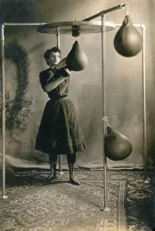 Effort Prints: United States: c. 1890 A young woman in a skirt working out with boxing gloves and a punching bag