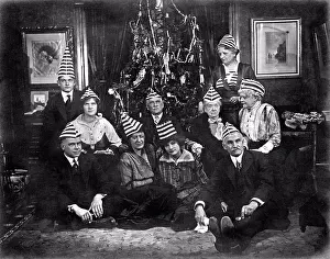 Holidays Prints: United States: c. 1915. A family with an interesting Christmas tradition of strange hats and weird expressions
