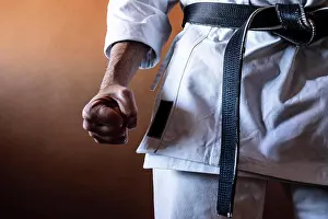 Uniform Prints: Unrecognizable karateka with black belt in firm position