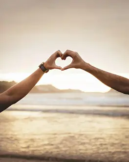 Lgbt Prints: Two unrecognizable men gesturing heart with hands in sunset lights