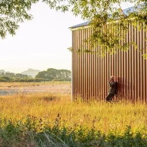 Using Phone Prints: USA, Idaho, Bellevue, Farmer leaning against farm building and talking on phone