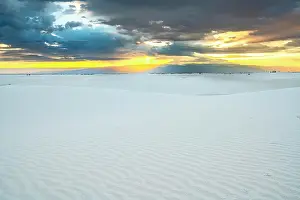 USA, New Mexico, White Sands National Park. Storm clouds over desert at sunrise