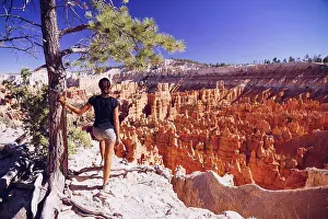 Only One Prints: USA, Utah, young female tourist looking down to the Hoodoo rock formations in Bryce Canyon National Park