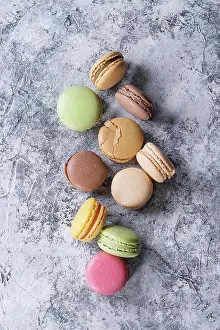 Pink Prints: Variety of colorful french sweet dessert macarons with different fillings served over gray texture background