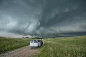 Threatening Prints: Vehicle sits on an off-road in the countryside as people photograph