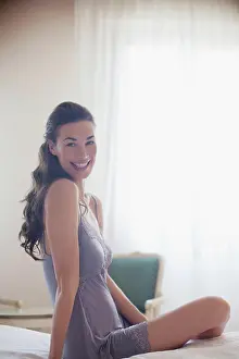 Venice, Portrait of smiling woman in nightgown on bed