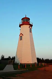 Lighthouse Prints: A vertical image of the famous tourist attraction Seacow Head Lighthouse Prince Edward Island in the evening light of