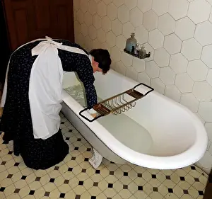 England Prints: Victorian bath with butler pouring hot water in a tiled en-suite bathroom