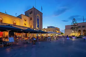 Large Group Of People Prints: View of cafe and restaurant in Eleftherias Central Square in Kos Town at dusk